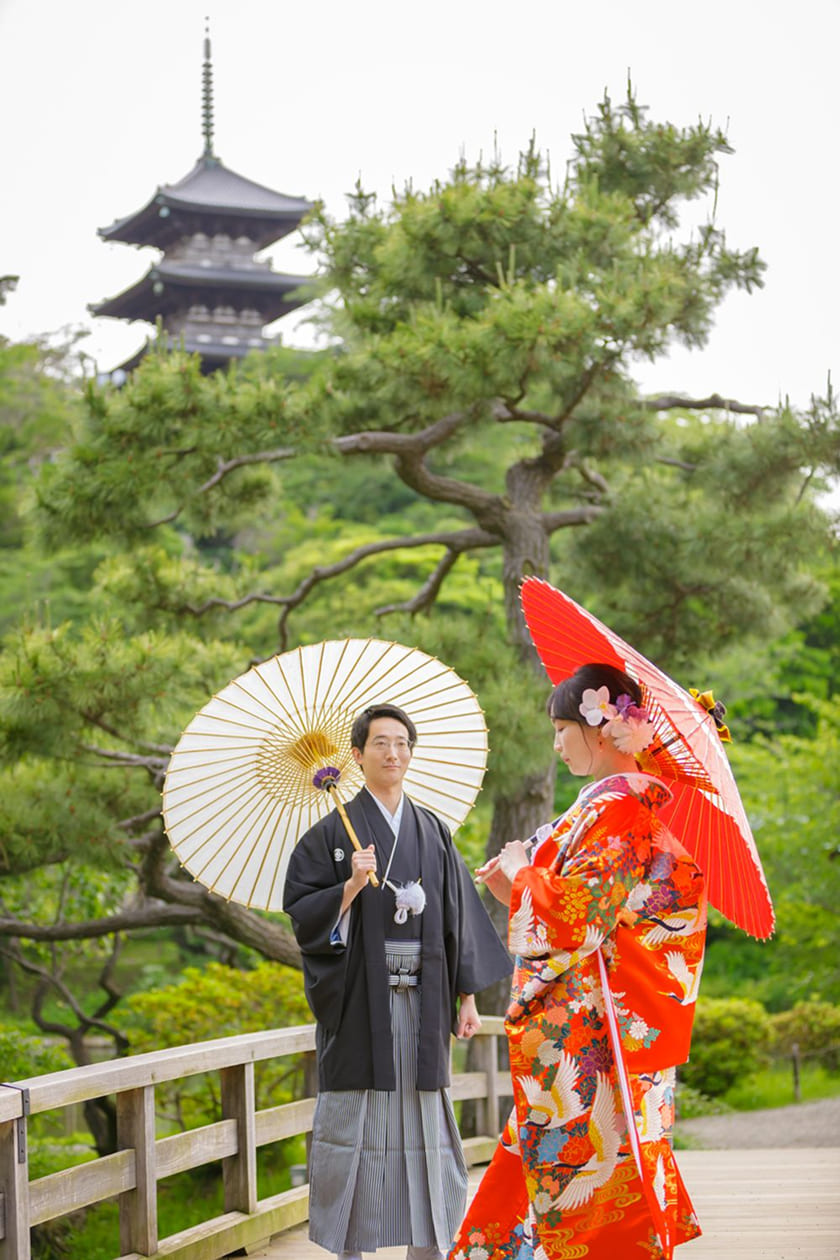 日本庭園の橋の上で見つめ合う新郎新婦