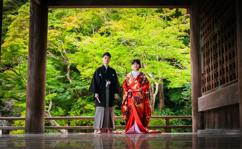 緑に包まれたお寺の中で佇む新郎新婦