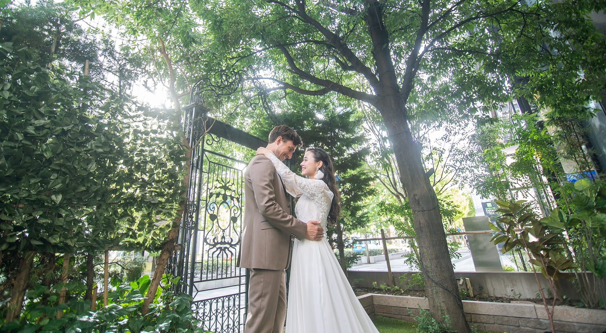 緑あふれるガーデンで見つめあっている新郎新婦
