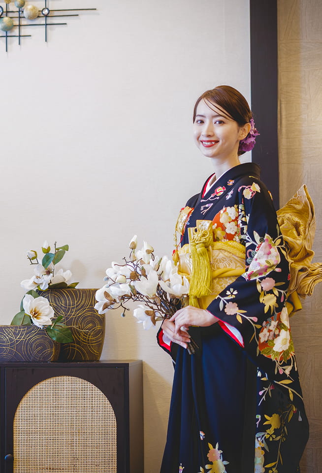 紺色の和装に身を包み、微笑んでいる新婦