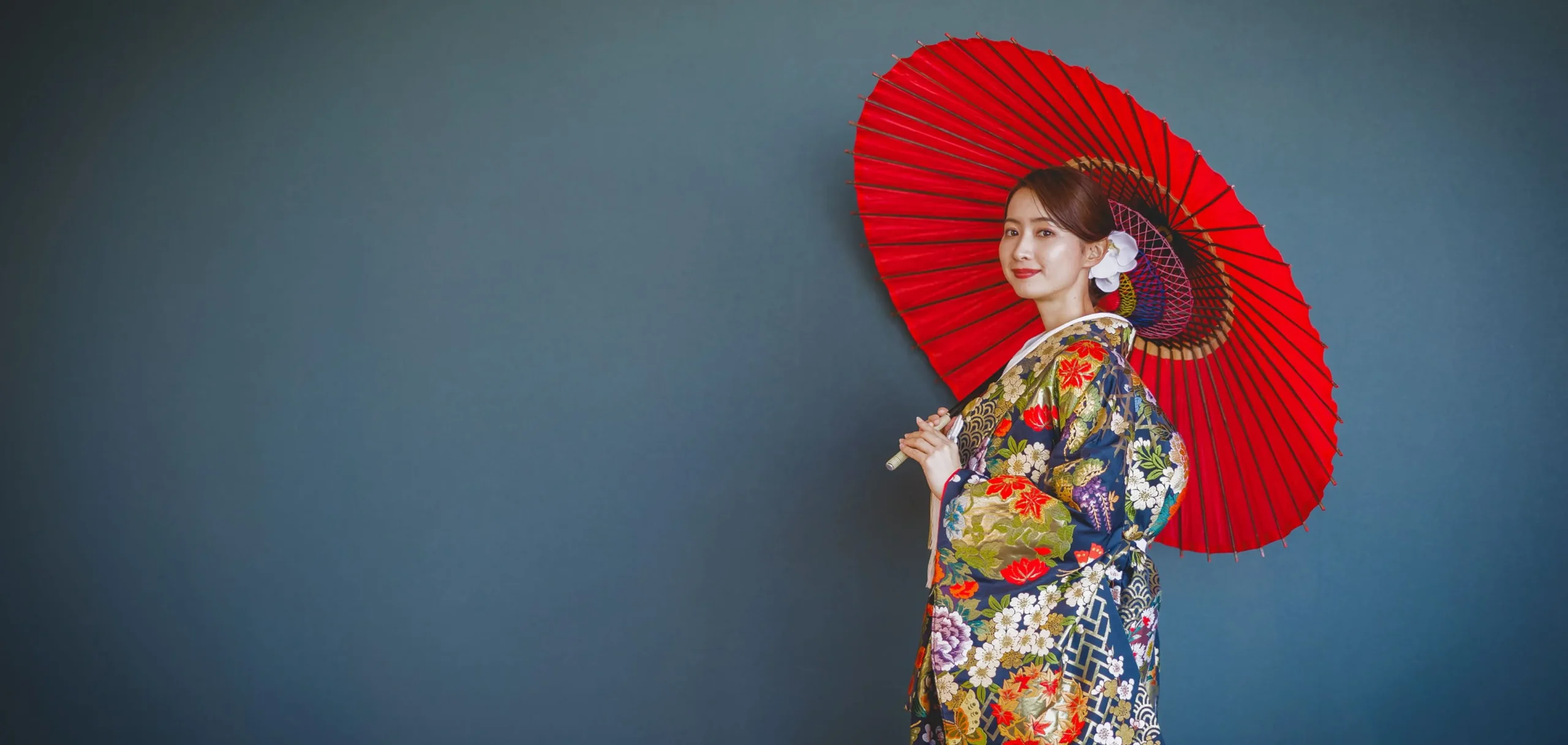 和傘を持って笑っている和装の新婦