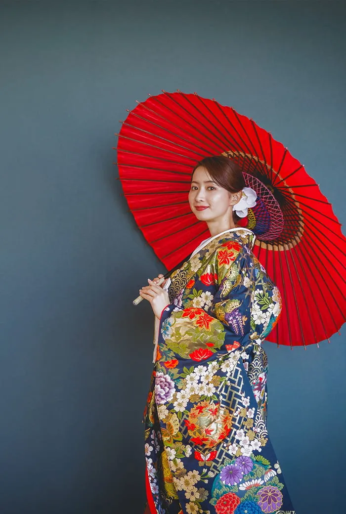 和傘を持って笑っている和装の新婦