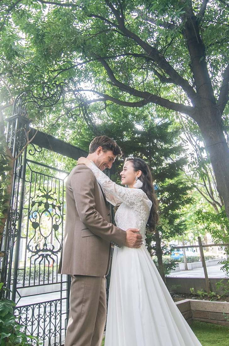 緑あふれるガーデンで見つめあっている新郎新婦
